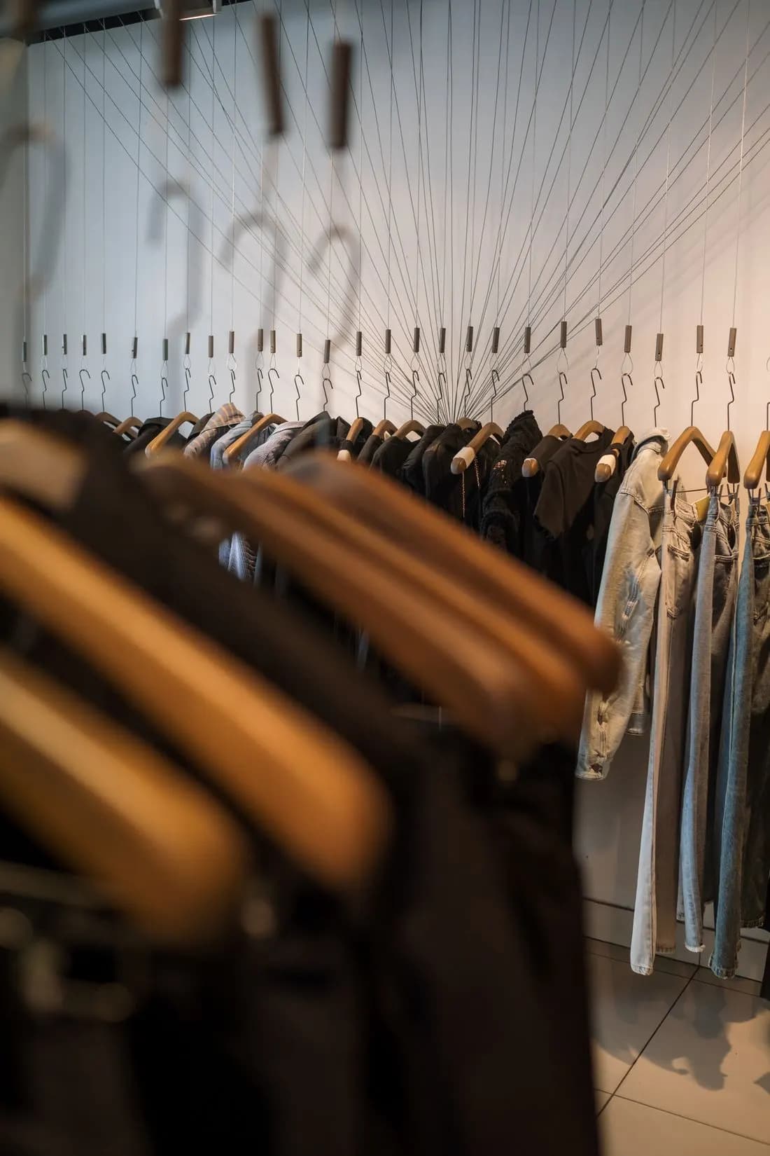 Shirts and trousers on wooden hangers in a clothing store